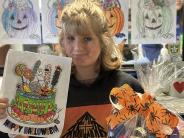 A girl holding a colored page and a basket of gifts, a wall of colored pages behind her.