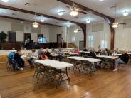 People sitting at tables in a large hall playing BINGO.