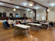 People sitting at tables in a large hall playing BINGO.